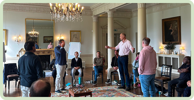 A group of individuals engaged in a leadership workshop in an elegant room.